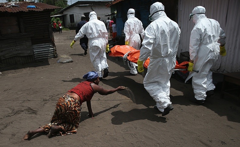 当地时间2014年10月10日，利比里亚首都蒙罗维亚，运尸队将感染埃博拉死亡的尸体运去火化，亲人悲痛欲绝。在利比里亚，火化尸体不符合当地传统文化 图片来源：视觉中国.jpg