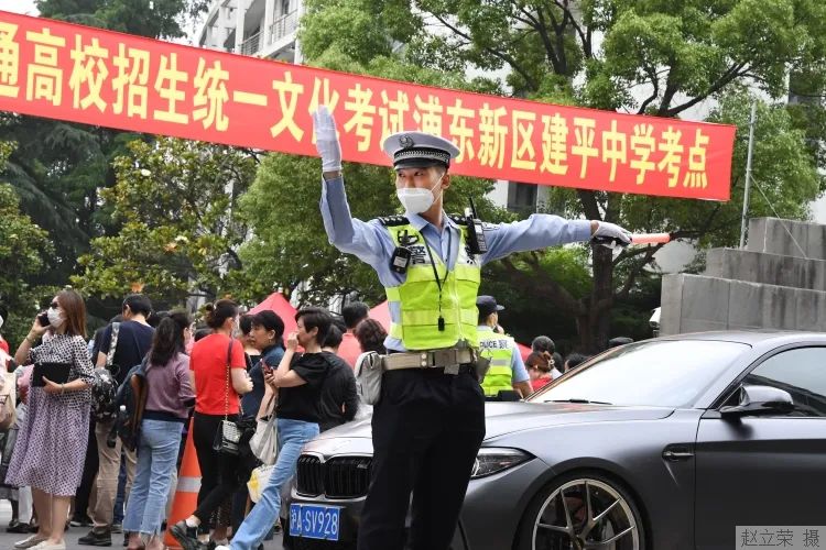 浦东新区公安分局交警支队一大队民警在建平中学考点外维持交通秩序。