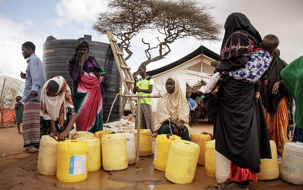 当地时间2023年3月23日，肯尼亚达达布难民营，人们在取水。世界卫生组织说，非洲索马里遭遇40年来最严重的干旱，每天有400到500人抵达难民营。