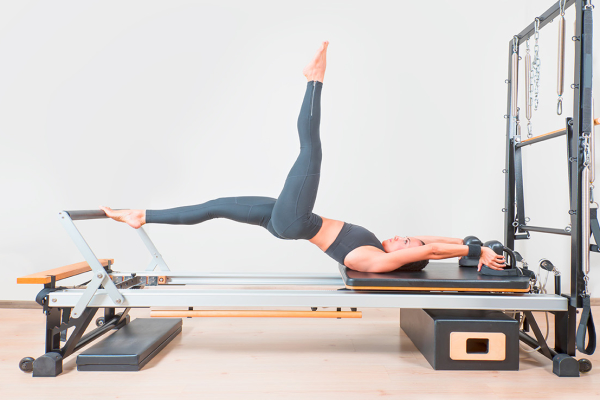 Young,Girl,Doing,Exercise,Of,Pilates,,Reformer,Bed