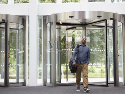 Middle aged black man entering the foyer of modern building