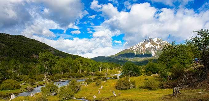 A landscape with a river and mountains
Description automatically generated