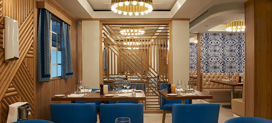 A restaurant with blue chairs and tables
Description automatically generated