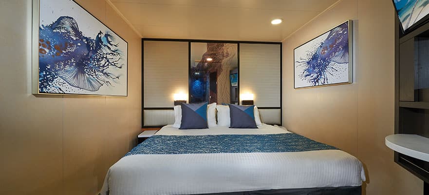 A bed with pillows and a lamp
Description automatically generated