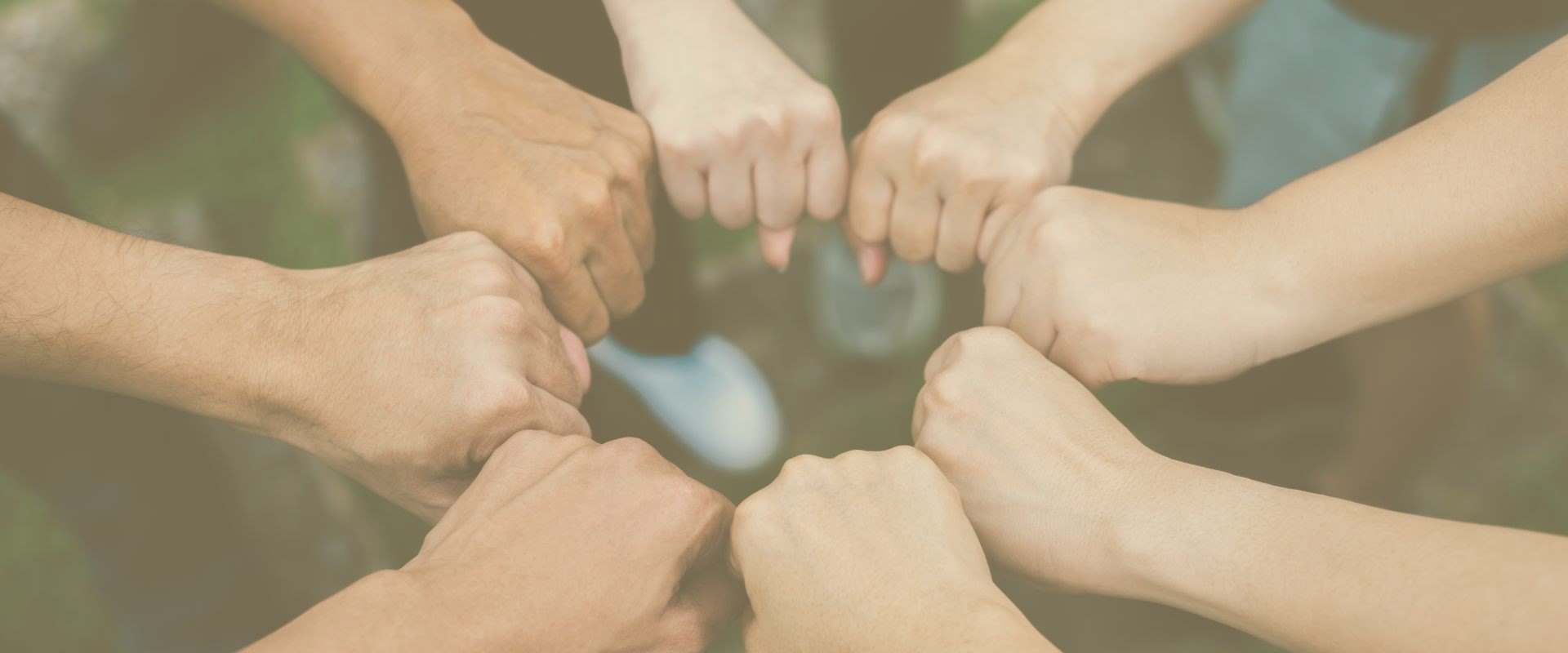 Close up of students standing hands making fist bump gesture.