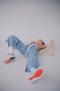 person in blue denim jeans and red sneakers 穿蓝色牛仔布牛仔裤和红色运动鞋的人