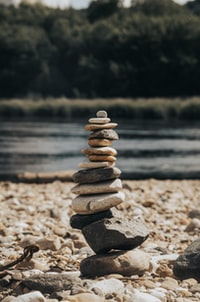 stack of gray stones near body of water during daytime 白天靠近水体的一堆灰色石头