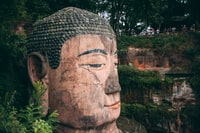 brown concrete statue near green plants during daytime 白天绿色植物附近的褐混凝土雕像
