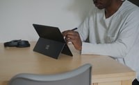 man in white shirt using black laptop computer 穿着白色衬衫的男子使用黑色笔记本电脑