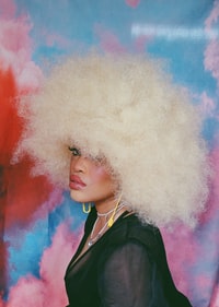 woman in black coat with white and pink powder on her face 身穿黑色外套，脸上涂着白色和粉红色粉末的女人