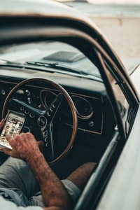 person holding black steering wheel 手持黑色方向盘的人