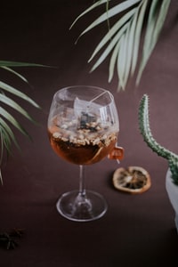 clear wine glass with brown liquid 带棕色液体的清澈的酒杯