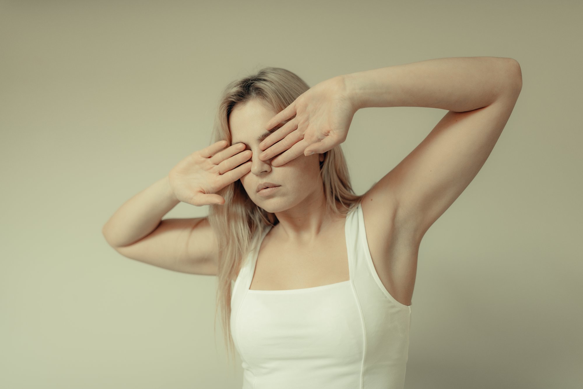 woman stands and covers her eyes with her palms outwards 女人站着，用手掌向外捂住眼睛。