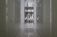 people walking on hallway inside building 人们在大楼内的走廊上行走