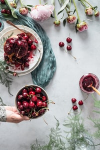 red cherries on white ceramic plate 白色陶瓷板上的红色樱桃