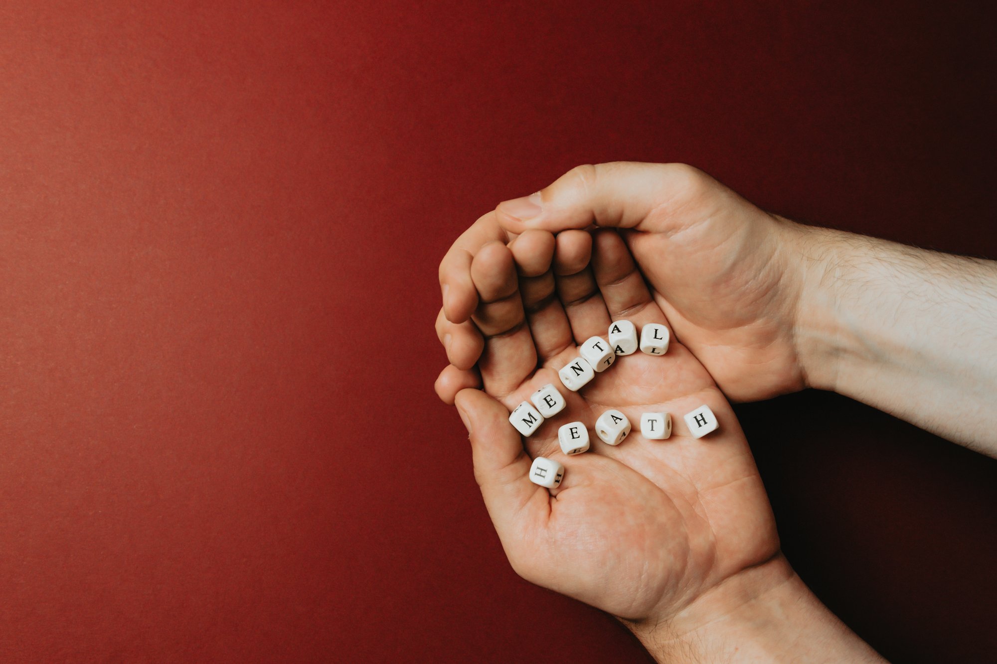 hands cup wooden blocks spelling the words mental health 手杯木块拼字精神健康