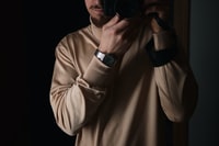 man in gray long sleeve shirt holding black dslr camera 身穿灰色长袖衬衫的男子手持黑色数码单反相机