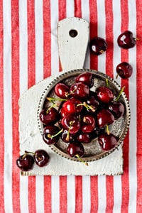 red cherries on brown ceramic bowl 棕色陶瓷碗上的红色樱桃