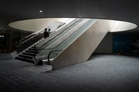 man in black jacket walking on gray concrete stairs