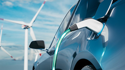 _0003_汽车在风车的背景下充电.充电电动车。电动汽车在风力涡轮机的背景下充电.使用可再生能源的车辆。3D渲染