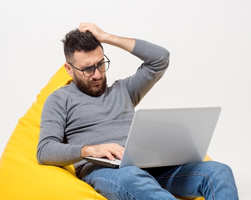 guy-frustrated-while-sitting-yellow-pouf-chair_72dpi
