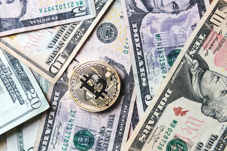 bitcoin-coin-on-bills-of-cash-money_925x